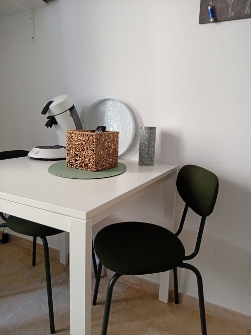 Bureau blanc avec objets de décoration et chaises noires dans la chambre d'hôtes Chez Laure & Marc, Plaissan