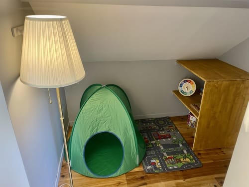 Chambre de cottage au Château de Vaux Morvan avec tente de jeu verte, lampadaire et mobilier en bois sur parquet