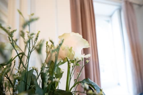 Delicate white carnation flowers in Liberté Apartment at Villa République Normandie, Caen, with window curtains and city view