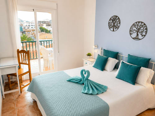 Bright bedroom at Apartamentos El Calón Playa with turquoise accents, sea view balcony, and modern amenities in Cuevas del