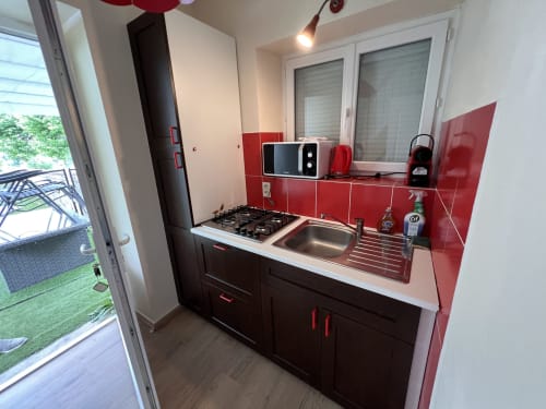 Cuisine cottage contemporaine avec dosseret rouge, cuisinière à gaz et vue sur le lac au Restaurant du Port B&B