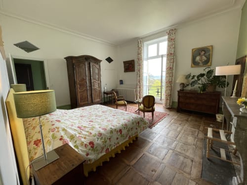 Chambre élégante du Château de Vaux Morvan avec couvre-lit fleuri, mobilier d'époque et vue sur les jardins à Étang sur Arroux