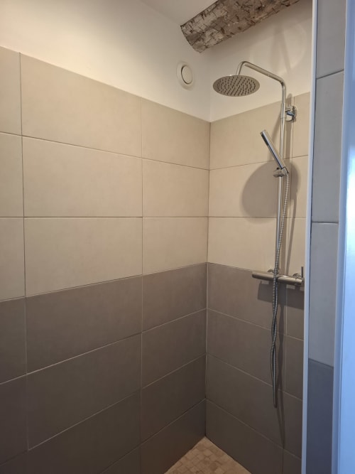 Douche moderne avec pomme de pluie et douchette à main à la maison d'hôtes Chez Laure & Marc à Plaissan, France