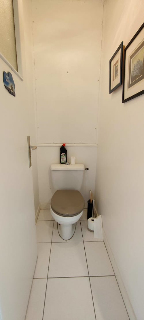 Toilettes compactes de l'appartement Mer et Maisons à La Trinité sur Mer avec carrelage blanc et accessoires de rangement