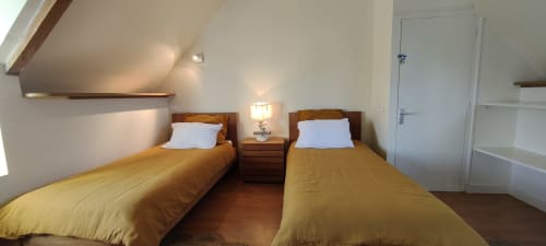 Chambre twin de la villa Mer et Maisons à La Trinité-sur-Mer avec literie jaune et mobilier en bois