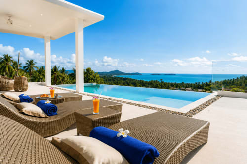 Luxury villa terrace at Indigo Villa Samui overlooking infinity pool and Koh Samui sea view with palm trees and mountains
