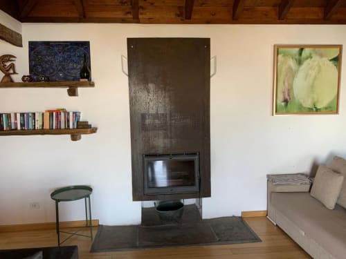 Sala de estar rústica con chimenea, estanterías de madera, sofá beige y cuadros de jardín en La Palma
