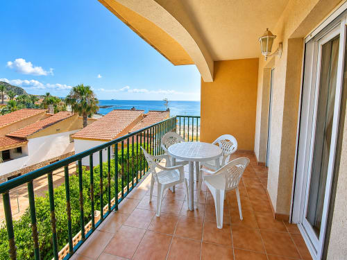 Terracotta balcony with sea views at Apartamentos El Calón Playa, Cuevas del Almanzora, featuring white furniture and
