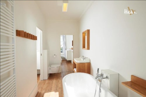 Modern bathroom in Hidden Bay Hotel Suite Juliette with white freestanding tub, wooden vanity, and wooden flooring in