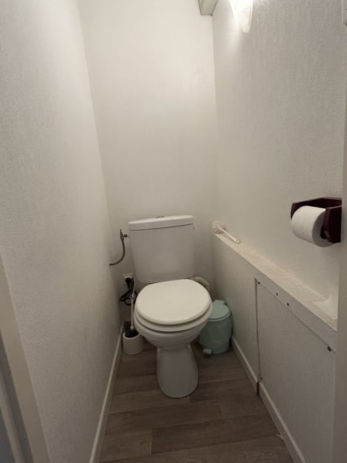 Petite salle de bains à Hébergement Luxeuil Les Bains studio, murs blancs et carrelage marron