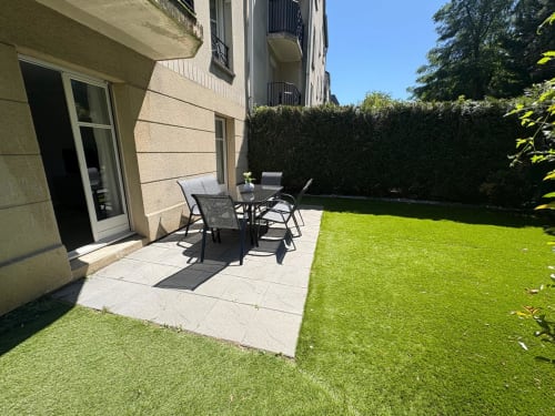 Jardin privatif avec terrasse aménagée, salon de détente et pelouse entretenue au Paradis Des Logis, Pierrefitte sur Seine