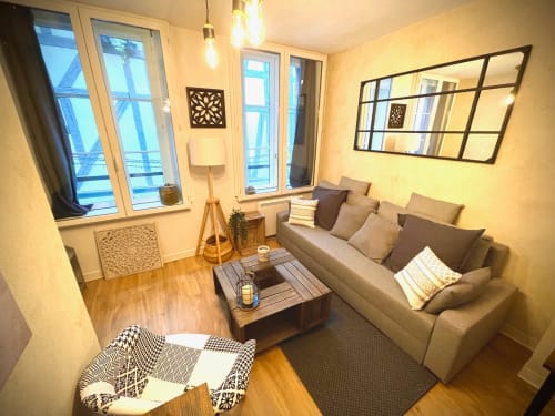 Séjour cosy de l'appartement Troyes avec canapé beige, parquet, vue sur la ville et décoration moderne au Paillot de Montabert