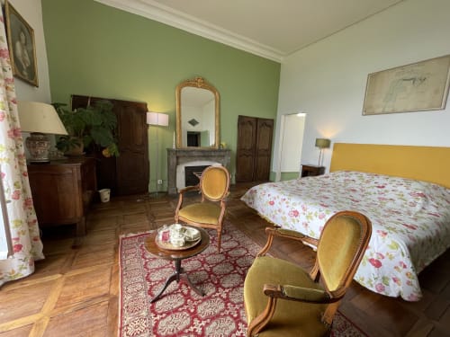 Chambre élégante du Château de Vaux Morvan avec literie fleurie, cheminée et mobilier français classique