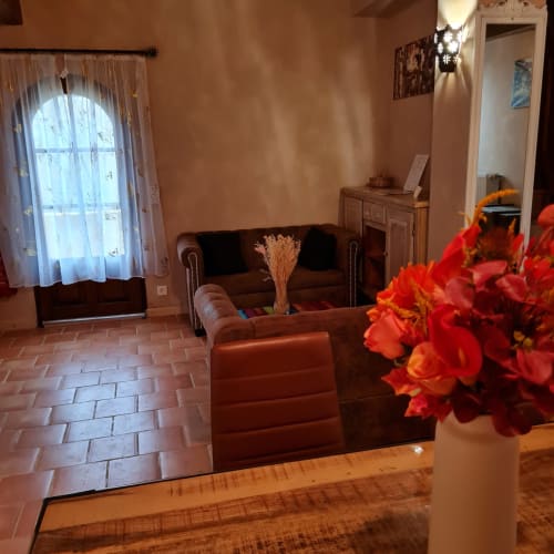Woonkamer van Gîte Cristal met bloemen en rustieke sfeer.