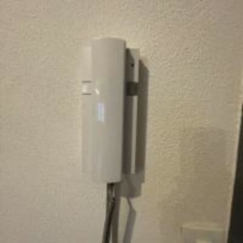 Routeur Wi-Fi blanc fixé au mur texturé beige d'un appartement à Perpignan