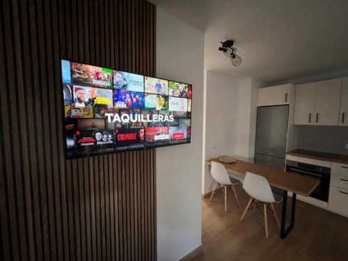 Cocina-comedor moderno en apartamento de La Palma con TV de pantalla plana y mobiliario contemporáneo