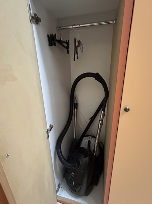 Rangement placard dans l'appartement Le Duplex 1 à Hébergement Luxeuil Les Bains avec aspirateur et accessoires de suspension