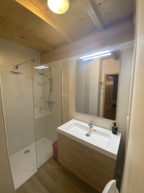 Salle de bain moderne de la chambre Chrysalide au Cocon De Curson avec douche à l'italienne, meuble vasque et miroir lumineux