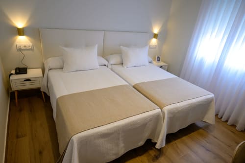 Dos camas individuales en luminosa habitación Superior del Hotel Boutique Alcazaba Salobreña con vistas a la ciudad y comodidades modernas