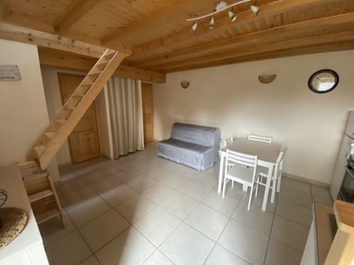Le Papillon cottage du Cocon De Curson offre poutres apparentes, carrelage, salle à manger, canapé et escalier vers loft