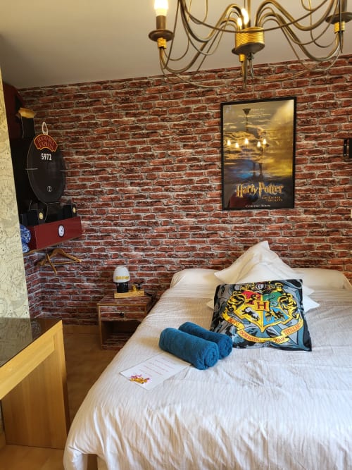 Chambre thématique Harry Potter à l'Hôtel Cheverny La Vie Est Belle avec mur de briques, coussin Poudlard et locomotive décorativo