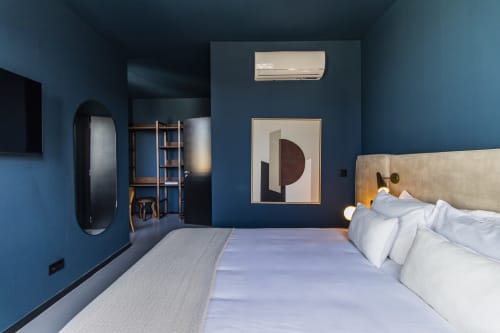 Quarto moderno do hotel Porto com paredes azuis, cama com lençóis brancos, obra de arte abstrata e ar-condicionado