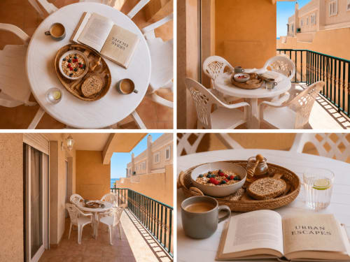 Desayuno soleado en la terraza de Apartamentos El Calón con café, cereales, tostadas y libro abierto con vistas a Cuevas del Almanzora