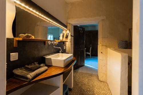 Salle de bain moderne de l'hôtel-boutique Le Mas F à Saint-Rémy-de-Provence avec vasque, miroir chauffant et carrelage en pierre
