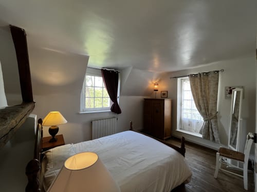 Chambre spacieuse au Cottage Jardin d'Aux Fleurs de Cerises avec lit queen-size, éclairage chaleureux et vue sur le jardin