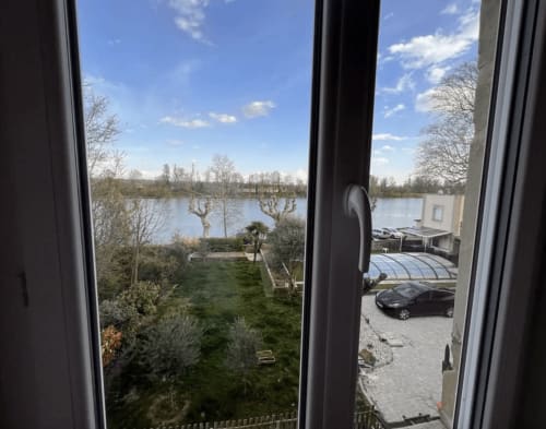 Vue sur le lac depuis le cottage du Restaurant du Port à Saint-Pierre-de-Boeuf, surplombant l'eau et les jardins