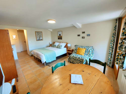 Bright bedroom with queen bed, dining table, sofa, and garden views at Sunflowers cottage, Les Gites de Campardon