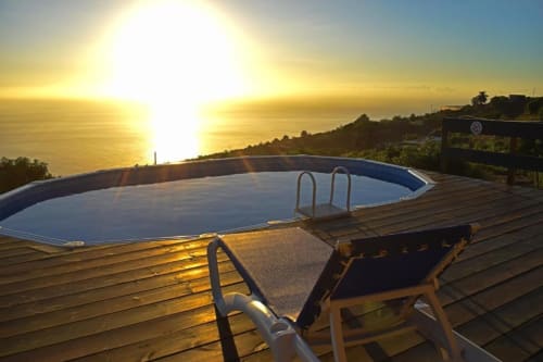Vista al atardecer del océano desde la terraza de la piscina de Villa Las Flores con tumbona en Tijarafe, La Palma