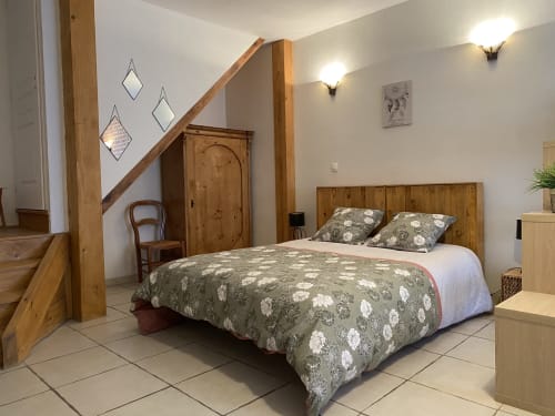 Chambre du gîte Le Cocon à Chanos-Curson, France, avec lit en bois et mobilier