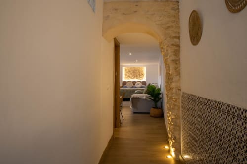 Moderner Flur mit Steingewölbe im Loft von Setenil de las Bodegas, führend zum Wohnbereich mit Ambientelicht und gewebten Textilien