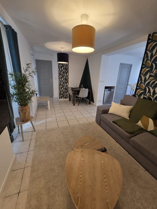 Salon moderne de l'appartement Residence Cosy à Saint-Méen-le-Grand avec canapé marron, table en bois et décoration contemporaine
