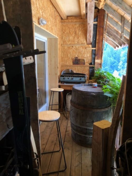 Cozy cottage kitchen with wooden barrel table, stove, and mountain views at Les Chalets de l'Eau Rousse, Celliers