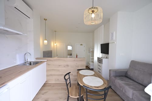 Estudio moderno en Hotel Boutique Alcazaba Salobreña con cocina abierta, comedor y sala de estar con televisión