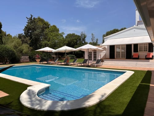 Villa de lujo en Las Golondrinas con piscina resplandeciente, sombrillas blancas, tumbonas y terraza moderna en Cap d'Artrutx