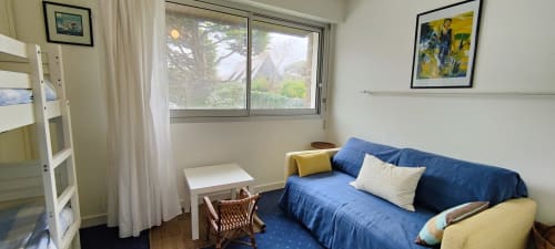 Chambre lumineuse à Mer et Maisons avec canapé bleu, vue sur mer et salon à La Trinité sur Mer