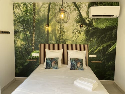 Chambre moderne à La Maison Blanche avec papier peint à motifs jungle, literie blanche, coussins décoratifs et luminaires suspendus