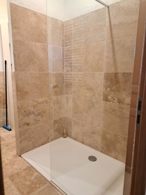 Douche à l'italienne avec carrelage en travertin et paroi vitrée à l'appartement Chez Laure & Marc à Plaissan