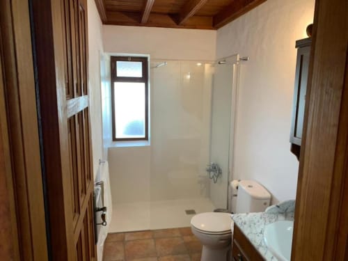 Baño moderno con ducha a ras de suelo, inodoro y lavamanos en Villa El Topo, apartamento rural en La Palma