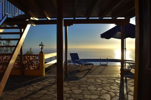 Vista al atardecer del océano desde la terraza de Villa Las Flores con tumbonas y sombrilla frente al mar en Tijarafe, La Palma