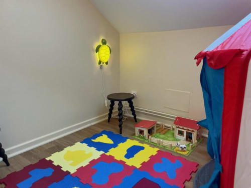 Salle de jeux colorée pour enfants au gîte Château de Vaux Morvan avec lampe tortue, tapis de mousse et tipi en tissu