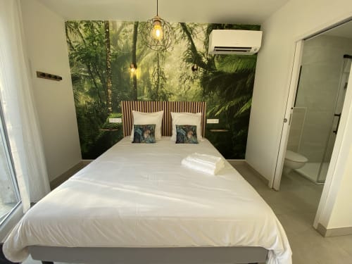Chambre d'hôte moderne à La Maison Blanche avec papier peint forêt tropicale, lit blanc et salle de bains attenante à Bouguenais