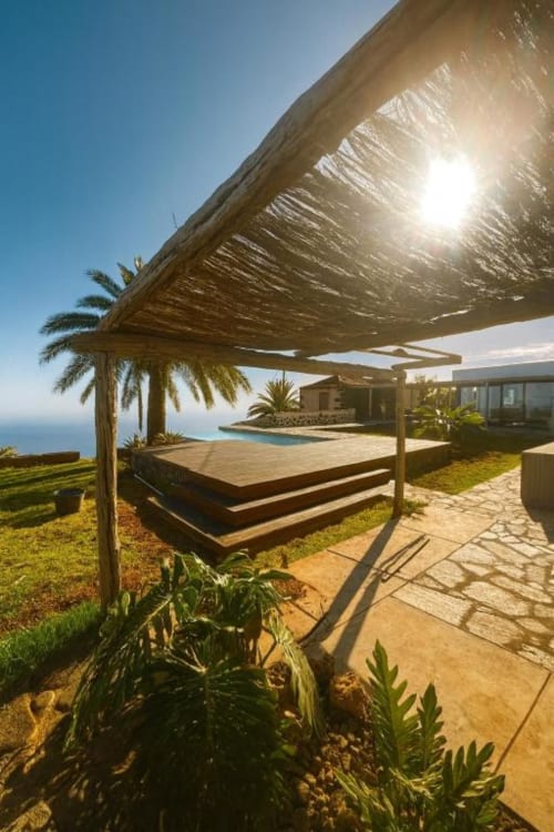 Terraza de villa con vista al océano en Rural La Palma, con pérgola de madera, piscina y paisaje mediterráneo en Tijarafe