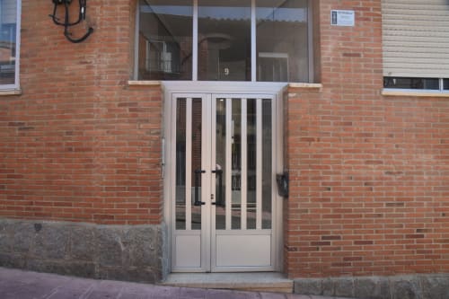 Entrance door to three-bedroom apartment in Benavente city center with brick facade and number 9
