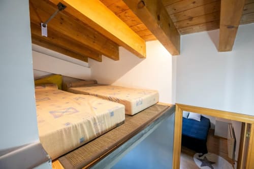 Acogedora habitación loft en apartamento de Montgat Prepirineo con vigas de madera vista, camas gemelas y vistas a la montaña
