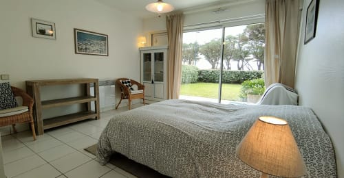 Chambre spacieuse à Mer et Maisons avec vue sur mer, lit queen-size, mobilier moderne et accès direct au jardin à La Trinité sur