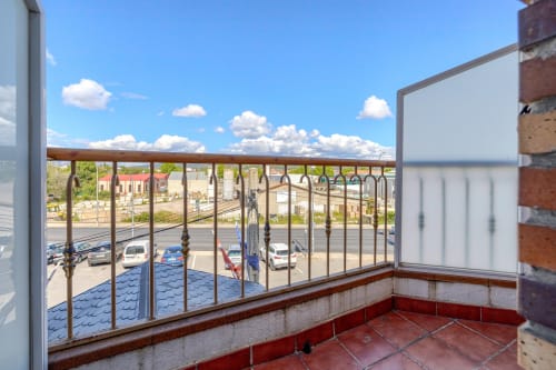 Vista de balcón desde habitación individual en Hostal El Molino de Collado Villalba con calles de la ciudad y cielo azul